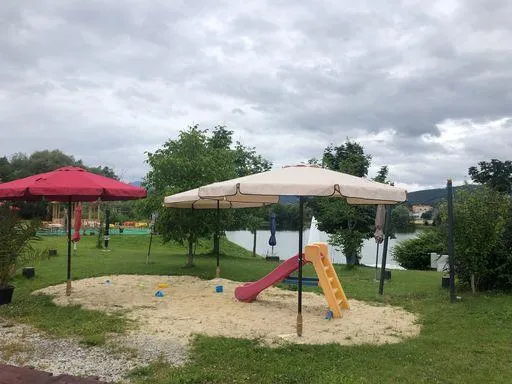 Kinderspielbereich mit Sandkasten und Rutsche am Badesee bei Flasch City near Deutschfeistritz / Gratkorn, familienfreundlicher Bereich nahe dem Wasser