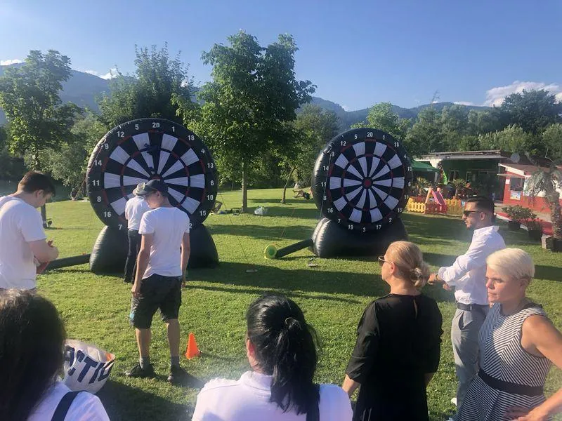 Besucher beim Riesen-Dartspiel auf der Wiese im Flasch City Restaurant-Cafe near hochsteiermark, verbindet Outdoor-Spass mit schnellem Mitnehmen von Speisen