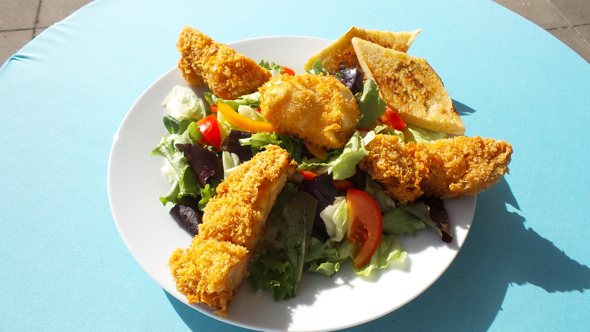 Frischer Salat mit knusprigem Haehnchen und Knoblauchbrot zum Mitnehmen im Restaurant-Cafe bei Flasch City near mediamarkt-st-lorenzen, ideal fuer eine leichte Mahlzeit am See