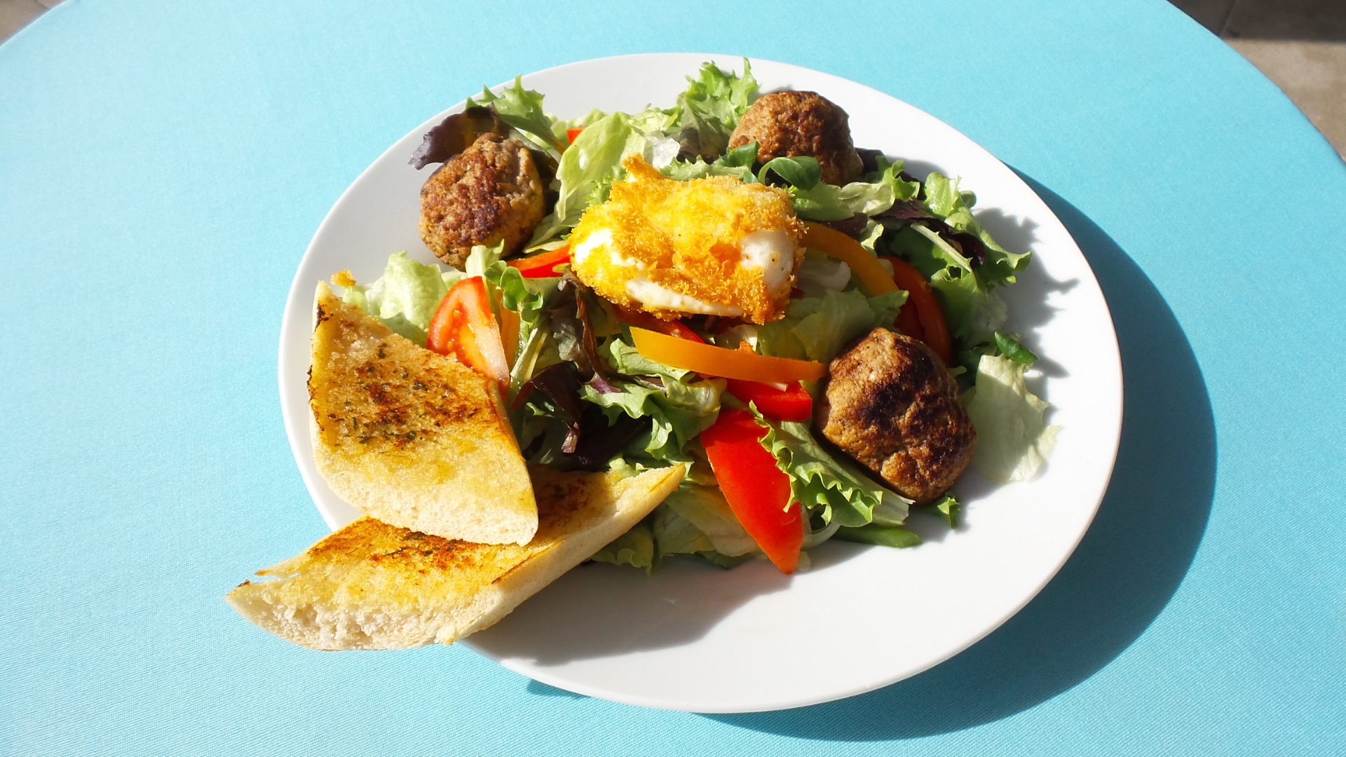 Gemischter Salat mit gebackenem Kaese, Fleischbaellchen und Knoblauchbrot zum Mitnehmen im Restaurant-Cafe bei Flasch City near kastner-oehler-st-lorenzen, perfekt fuer unkompliziertes Essen im Freien
