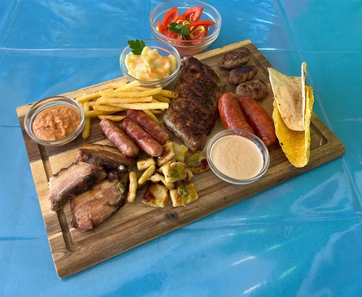 Gegrillte Fleischplatte mit Rippchen Wuerstel Pommes und Saucen im Flasch City restaurant-cafe near steiermark