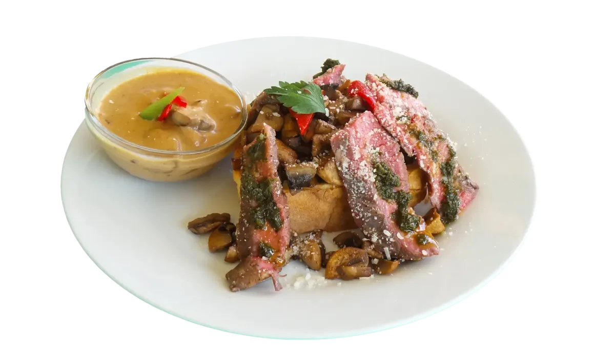 Geschnittenes medium-rare Steak mit Pilzen, Brot und cremiger Sauce im Flasch City steak restaurant-cafe near obersteiermark