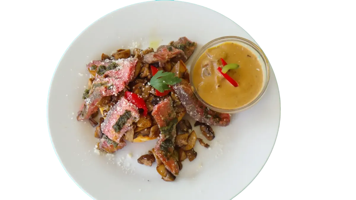 Draufsicht auf geschnittenes medium-rare Steak mit Pilzen und cremiger Sauce im Flasch City steak restaurant-cafe near obersteiermark