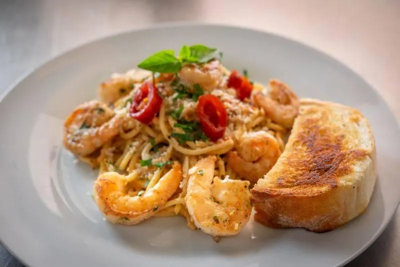 Garnelen-Spaghetti mit Kräutern und Knoblauchbrot im meeresfrüchte restaurant-cafe in Flasch City
