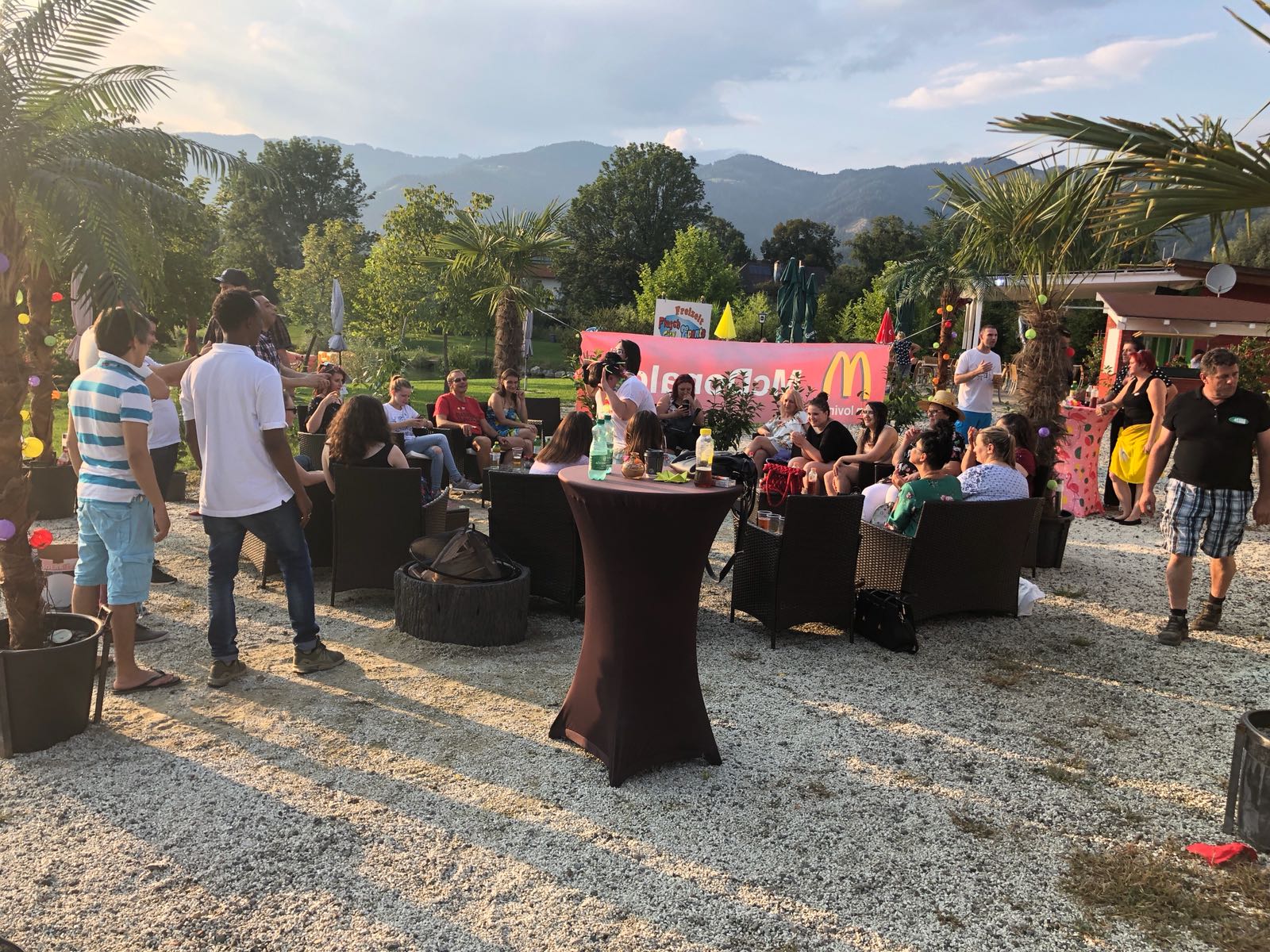 Gäste in einer Outdoor-Lounge bei Abendstimmung in der Flasch City Veranstaltungslocation nahe Hochsteiermark 