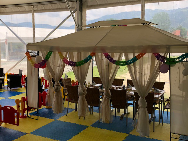 Überdachter Kindergeburtstag Bereich mit dekoriertem Sitzbereich bei Flasch City Kindergeburtstag Location