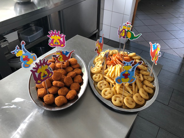 Kinder Party Essen mit Nuggets, Pommes und Smiley Kartoffeln auf Platten bei Flasch City Kindergeburtstag Location near steiermark