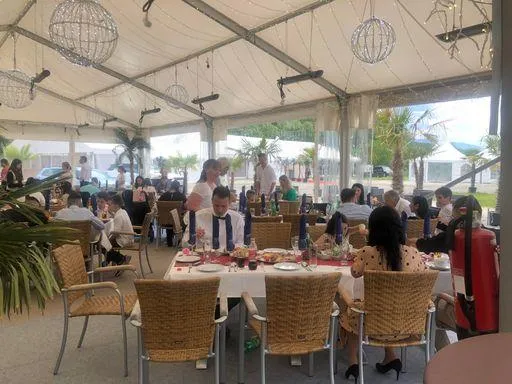 Gäste beim Essen und geselligen Beisammensein im hellen Zelt der Flasch City Eventlocation near Gloggnitz