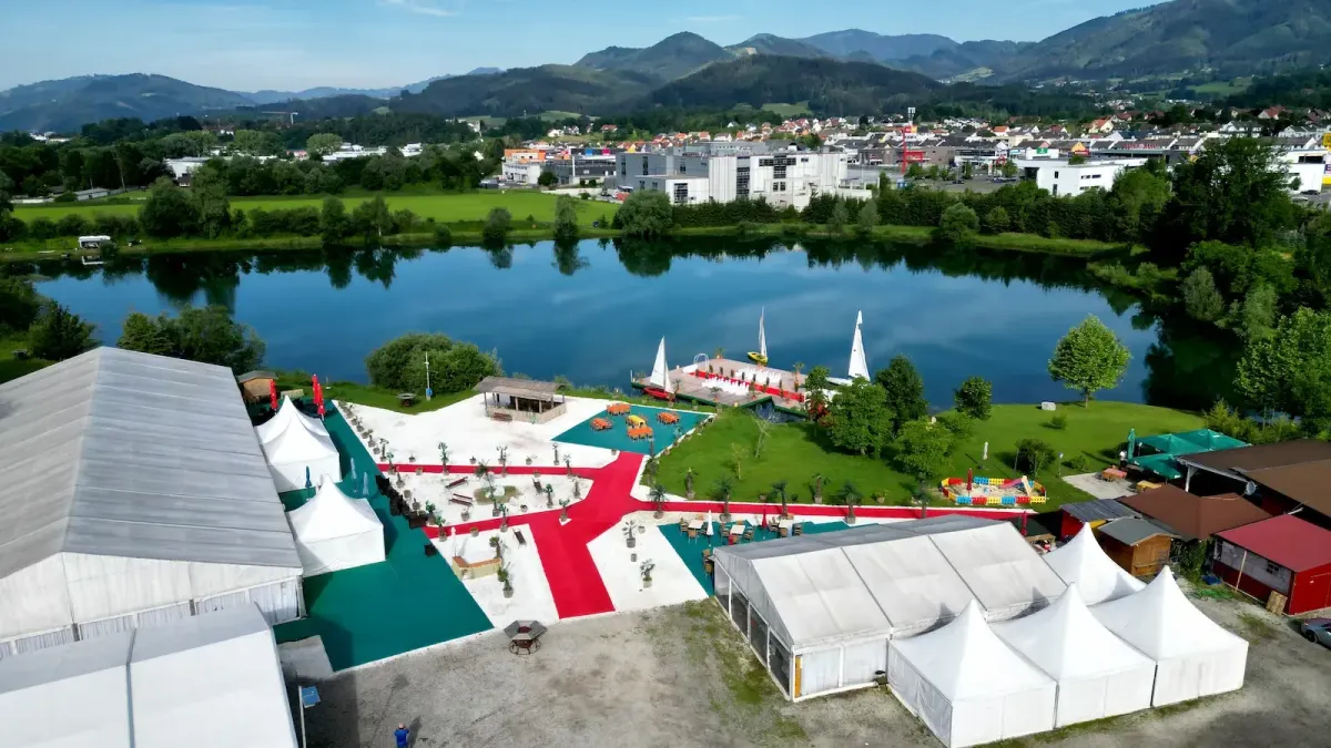 Außenbereich mit Seeblick, roten Wegen und Steg in der Flasch City Eventlocation near Müller Kapfenberg