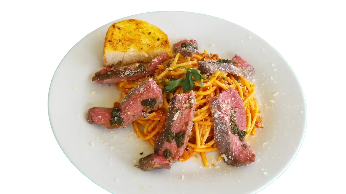 Spaghetti mit Steakstreifen, Kräutern und Knoblauchbrot im Flasch City italienischen Pasta Restaurant-Café