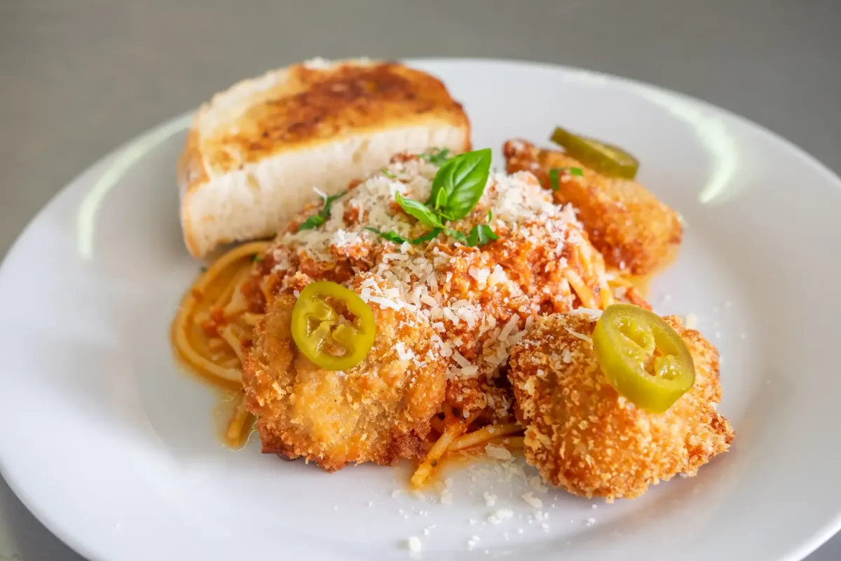 Spaghetti mit paniertem Huhn, Parmesan, Tomatensauce und Knoblauchbrot im Flasch City italienischen Pasta Restaurant-Café