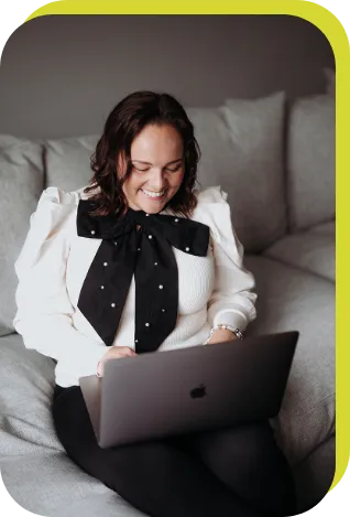 Nicola, founder of NM Creates sitting while on her laptop