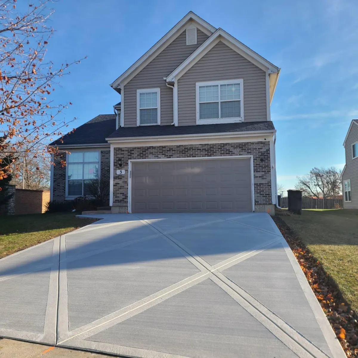 Big grey house with redone driveway