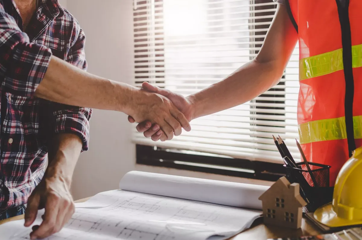 a client and an expert roofer shaking hands