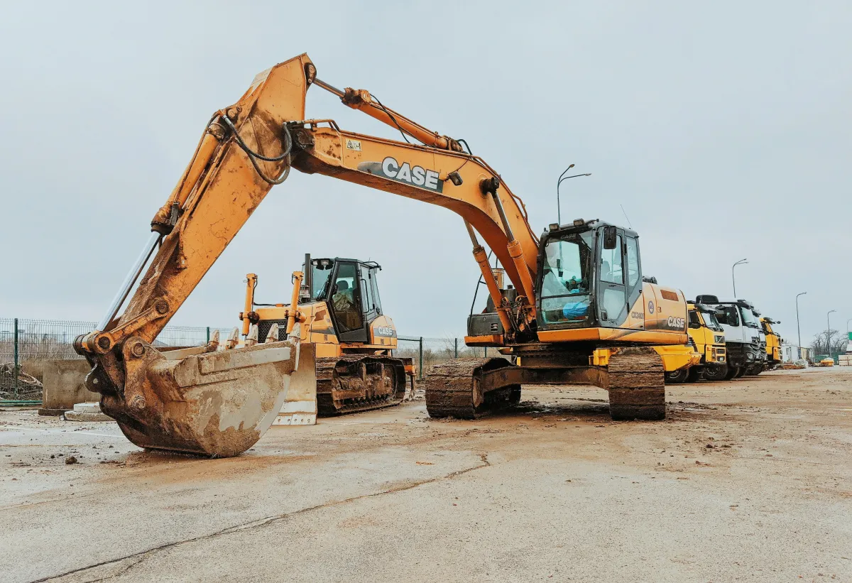 Tracked excavator and bulldozer parked on an open earthwork area.