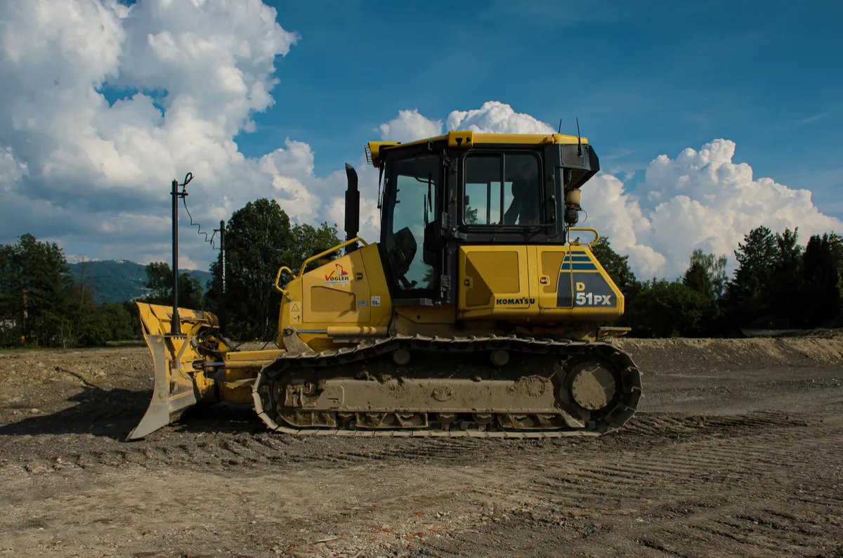 Tracked bulldozer on exposed ground with its blade lowered.