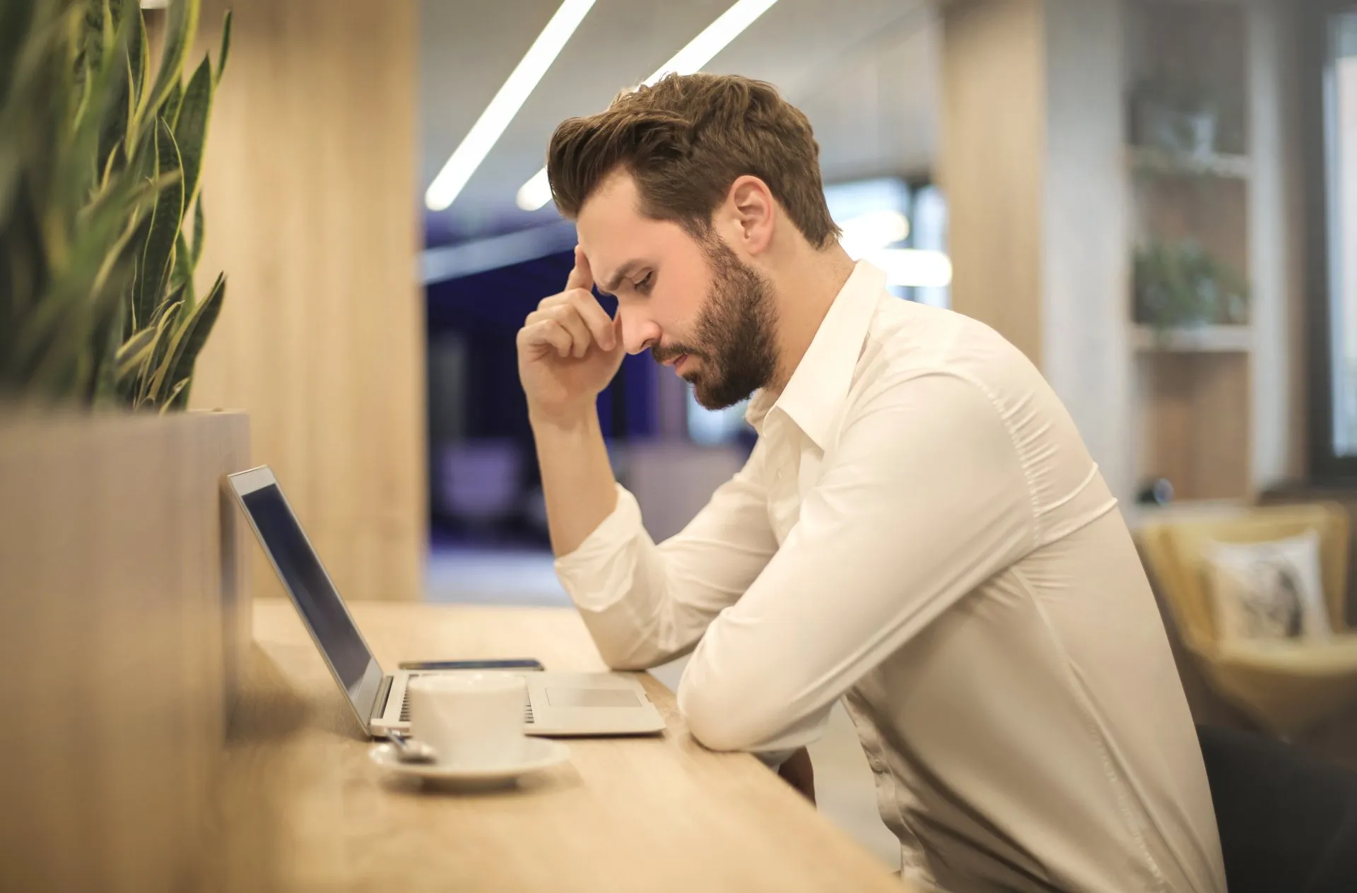 Man looking stressed and anxious working on a laptop