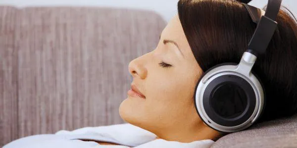 Woman relaxing with headphones getting biofeedback and bioresonance treatment