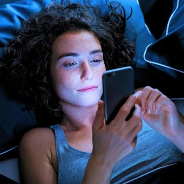 Woman engaged in unhealthy habit of using her cell phone in her bed at night