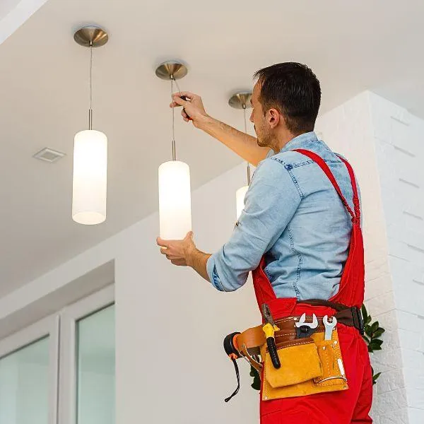 Worker fixing the lighting so that it doesn't emit dirty electricity