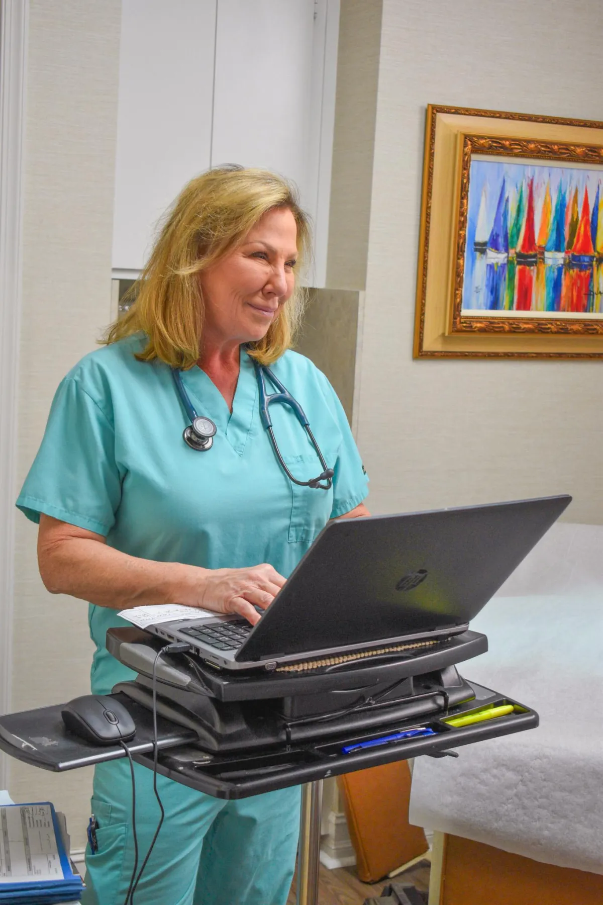 An image of Doctor Scherer smiling and working a patient room.