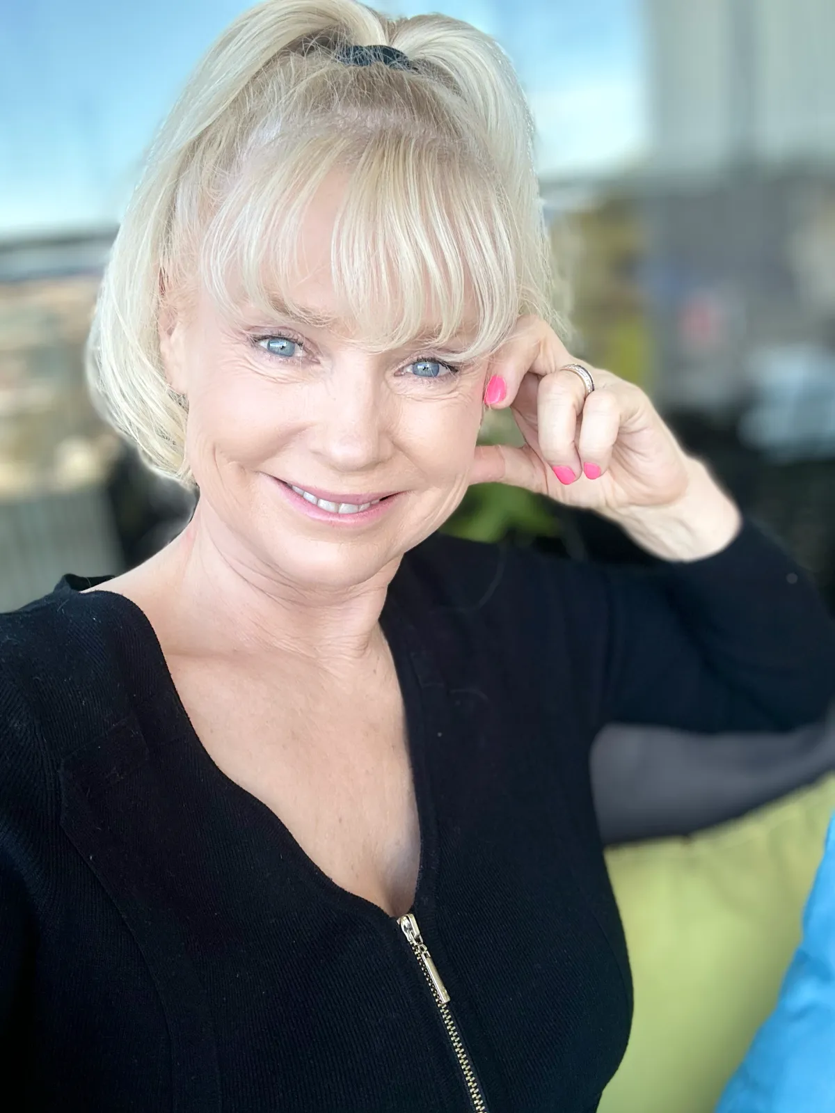 Experienced coach, mid-40s, sitting at a desk with open notebook and laptop, warmly engaging in a virtual session. The background features bookshelves and certificates, emphasizing credibility and approachability.