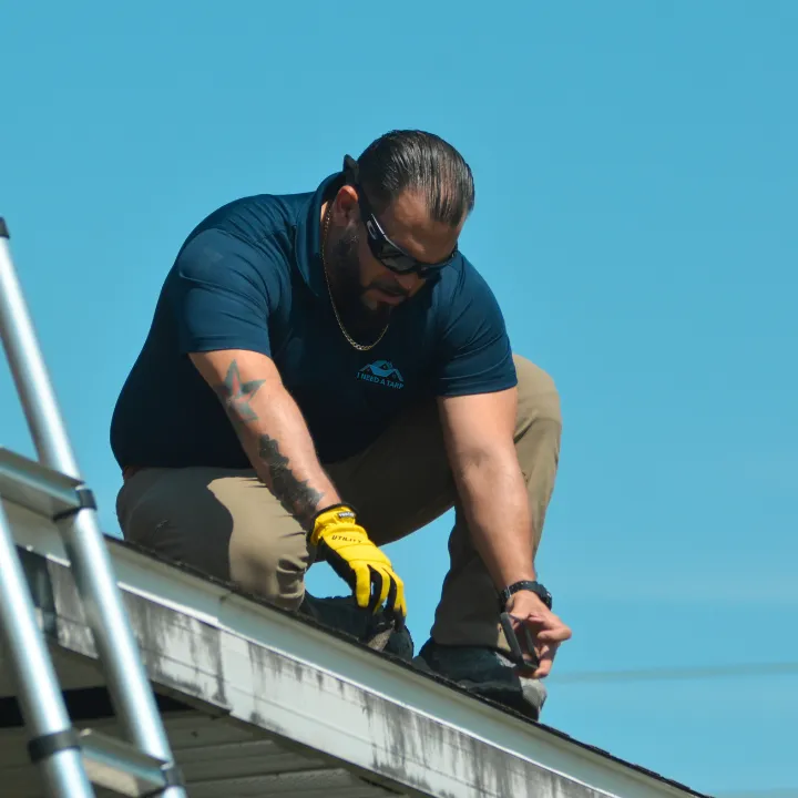 Technician inspecting a roof after storm damage