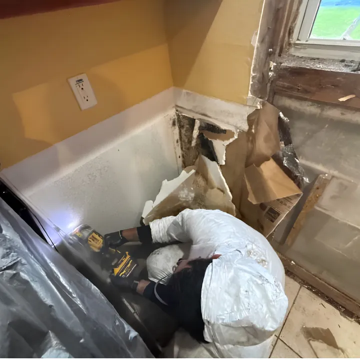 Baseboards removed and wall cavity opened for drying in a Doral property