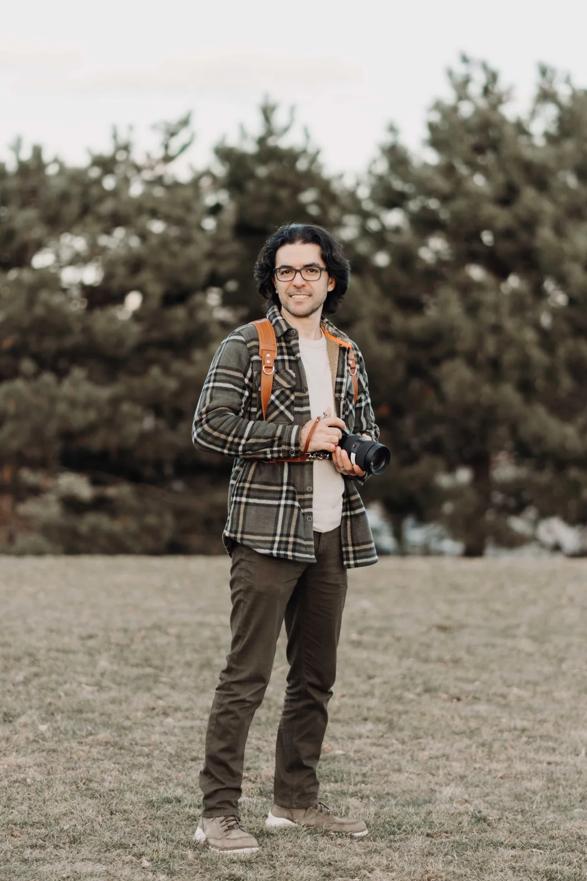 Amir Fathalian Toronto wedding photographer smiling at the camera and keeping his camera in his hand