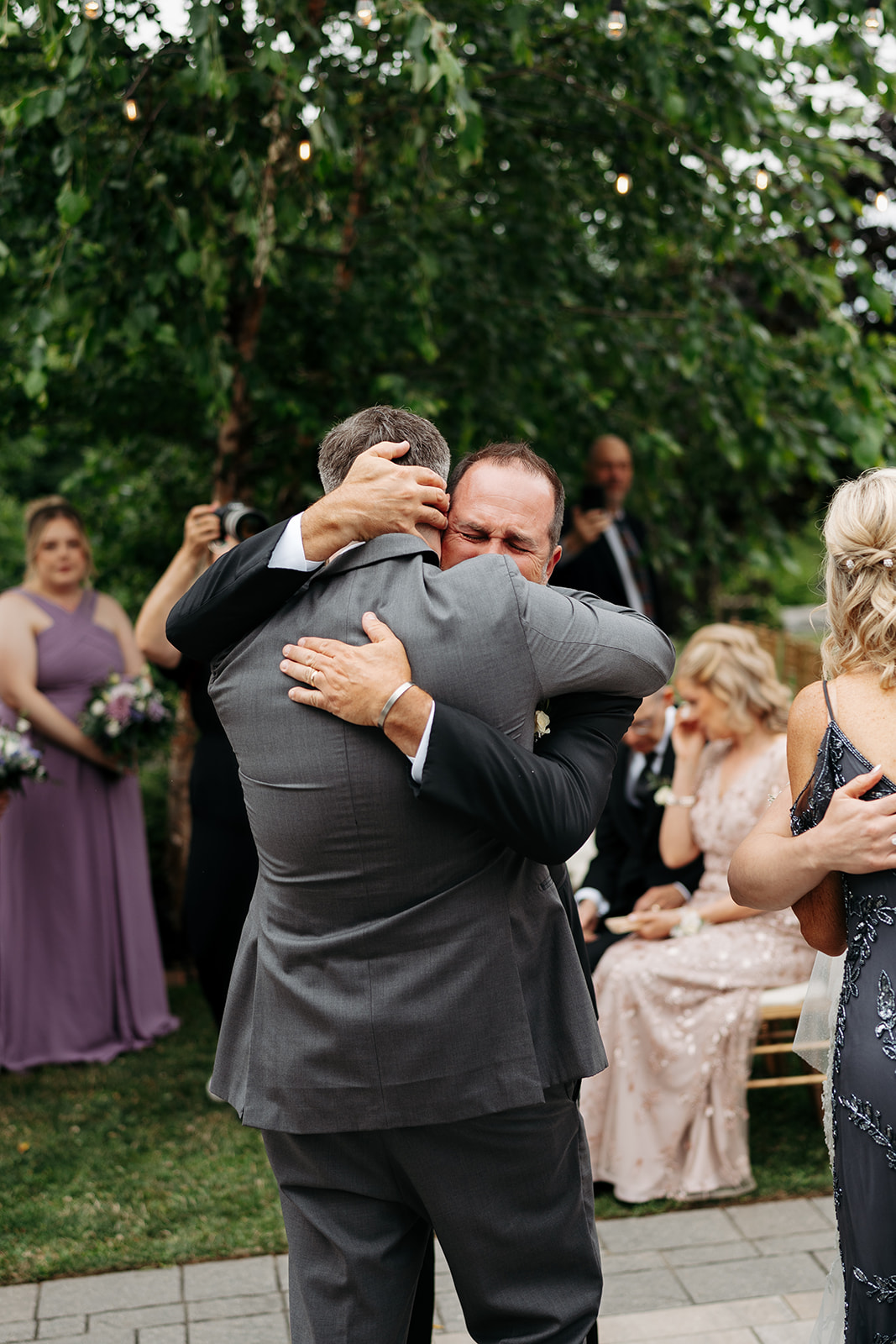 emotional moment before wedding ceremony where dad hugs his son and cries