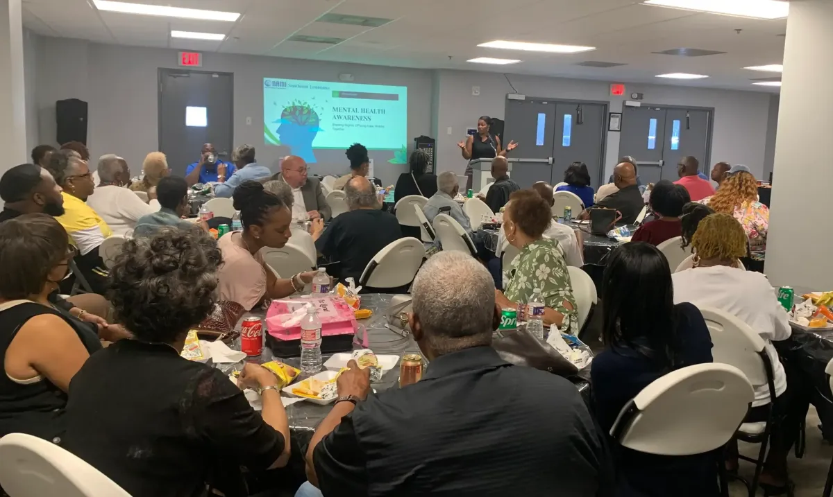 Guest listening to the presentation about mental health awareness at a God's Will Foundation community workshop. 🌿 a