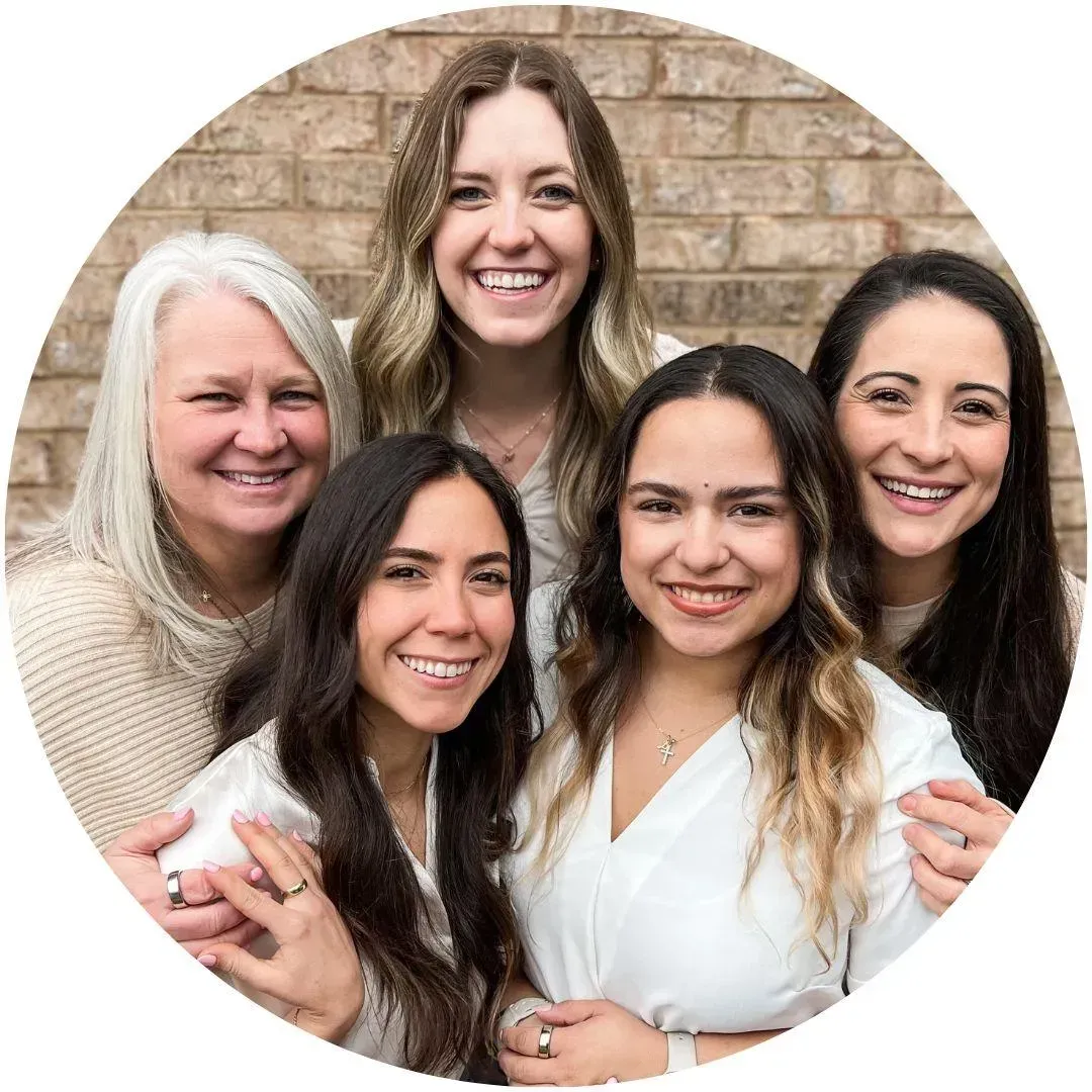 The all-women team at Perfect by Design, smiling and ready to assist patients.