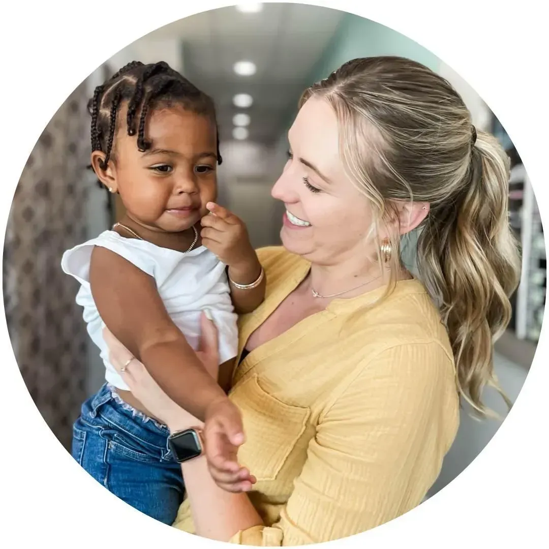 Dr Nikki hold a kid after her adjustment.
