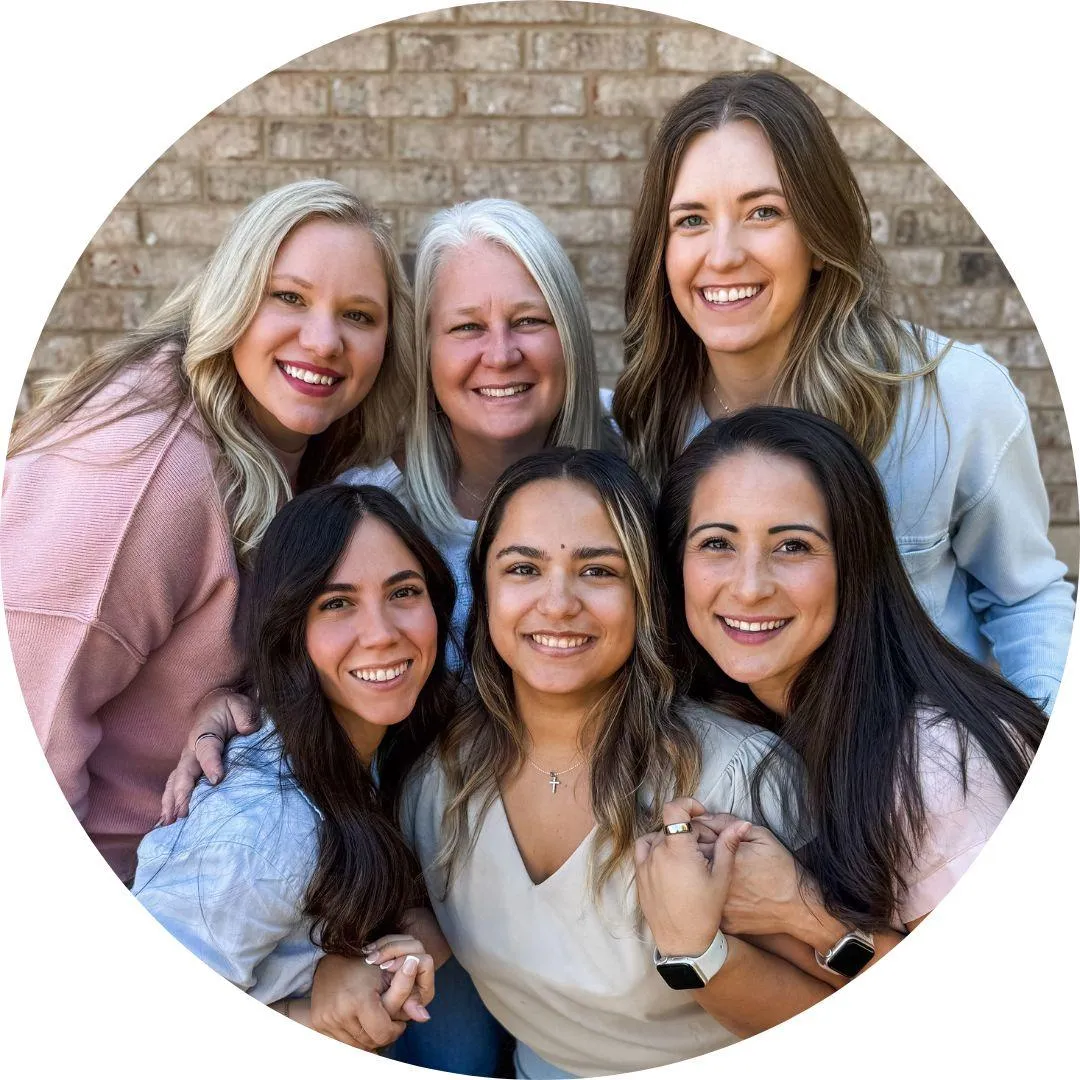 The all-women team at Perfect by Design, smiling and ready to assist patients.