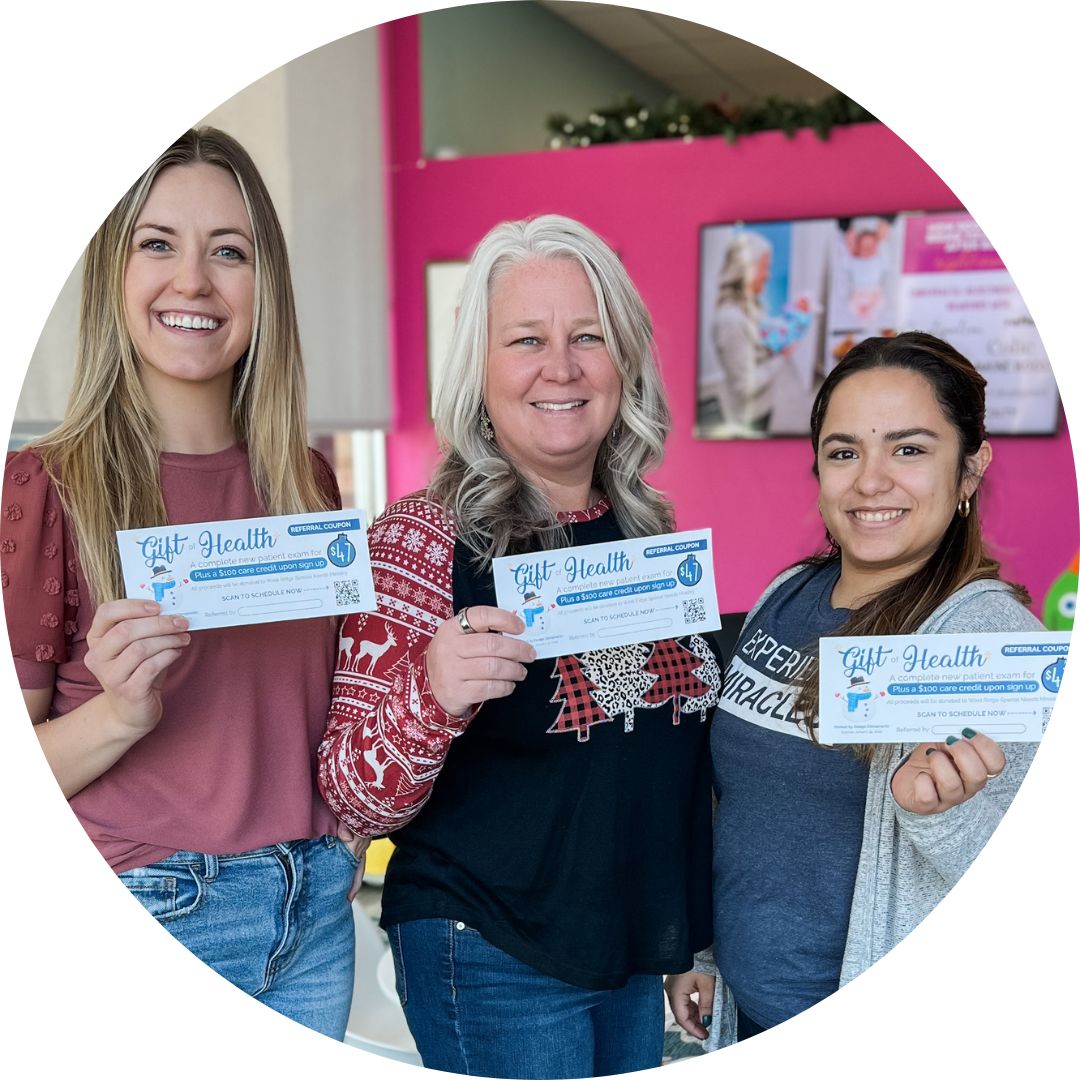 Two women, one pregnant, smiling together in a chiropractic office setting, highlighting prenatal care and support at Perfect by Design Pediatric & Prenatal Chiropractic.