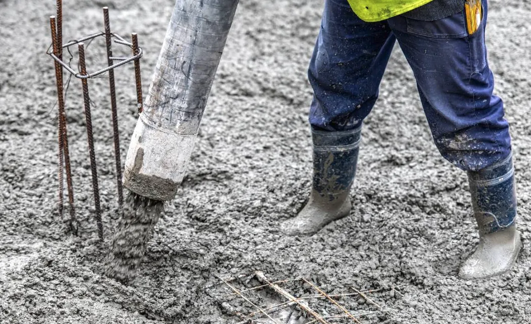 Concrete pumping - hose spewing wet concrete for new concrete slab