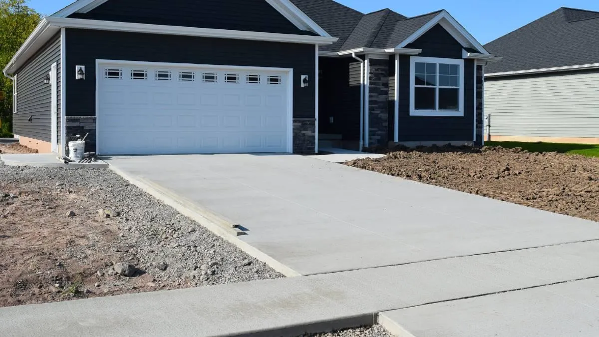 New concrete driveway installed blue house Roseville, CA