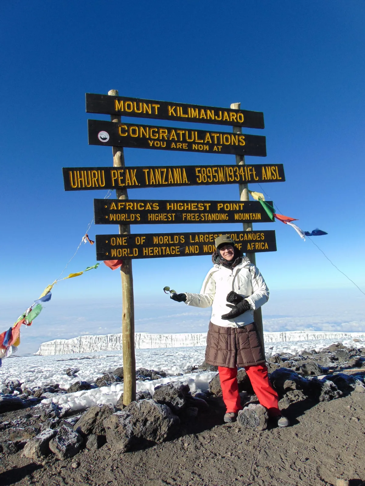 Dr. Liz standing at the summit of Mt. Kilimanjaro celebrating her 50th birthday climb