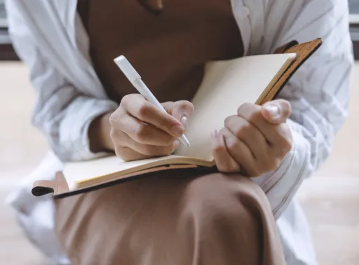 NZ woman business owner reviewing business growth numbers at a desk, considering whether to hire a business coach