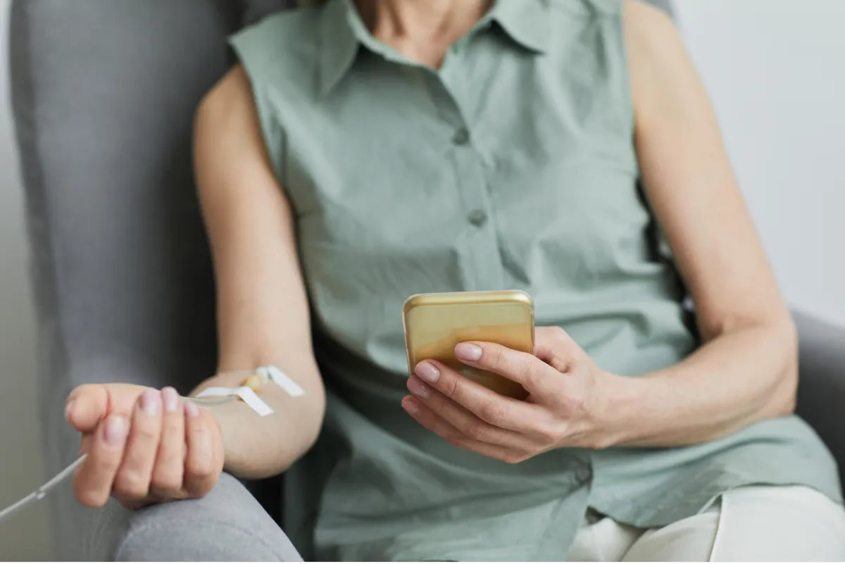Close-up of a nurse preparing an IV catheter injection on a patient's arm.