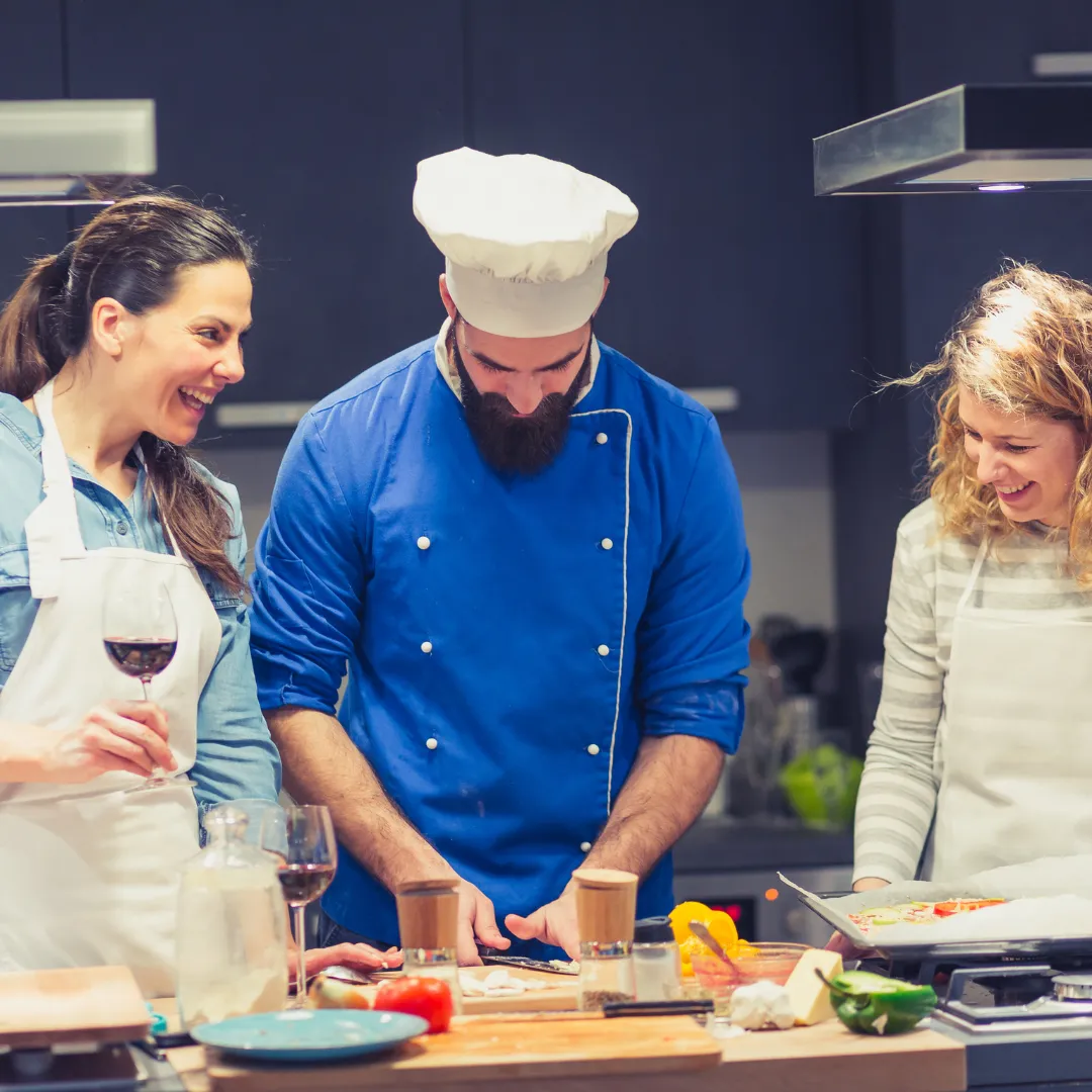A small group cooking together with a chef