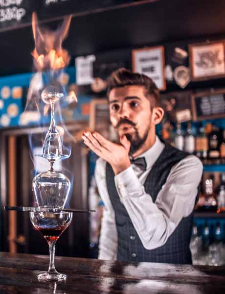 Bartender performing a flaming cocktail presentation.
