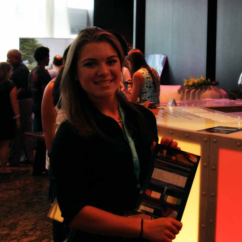 Woman holding a brochure at an event bar.