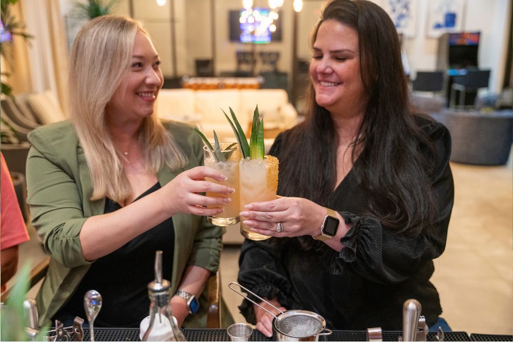 Wooden bar setup with bottles and bar stools.