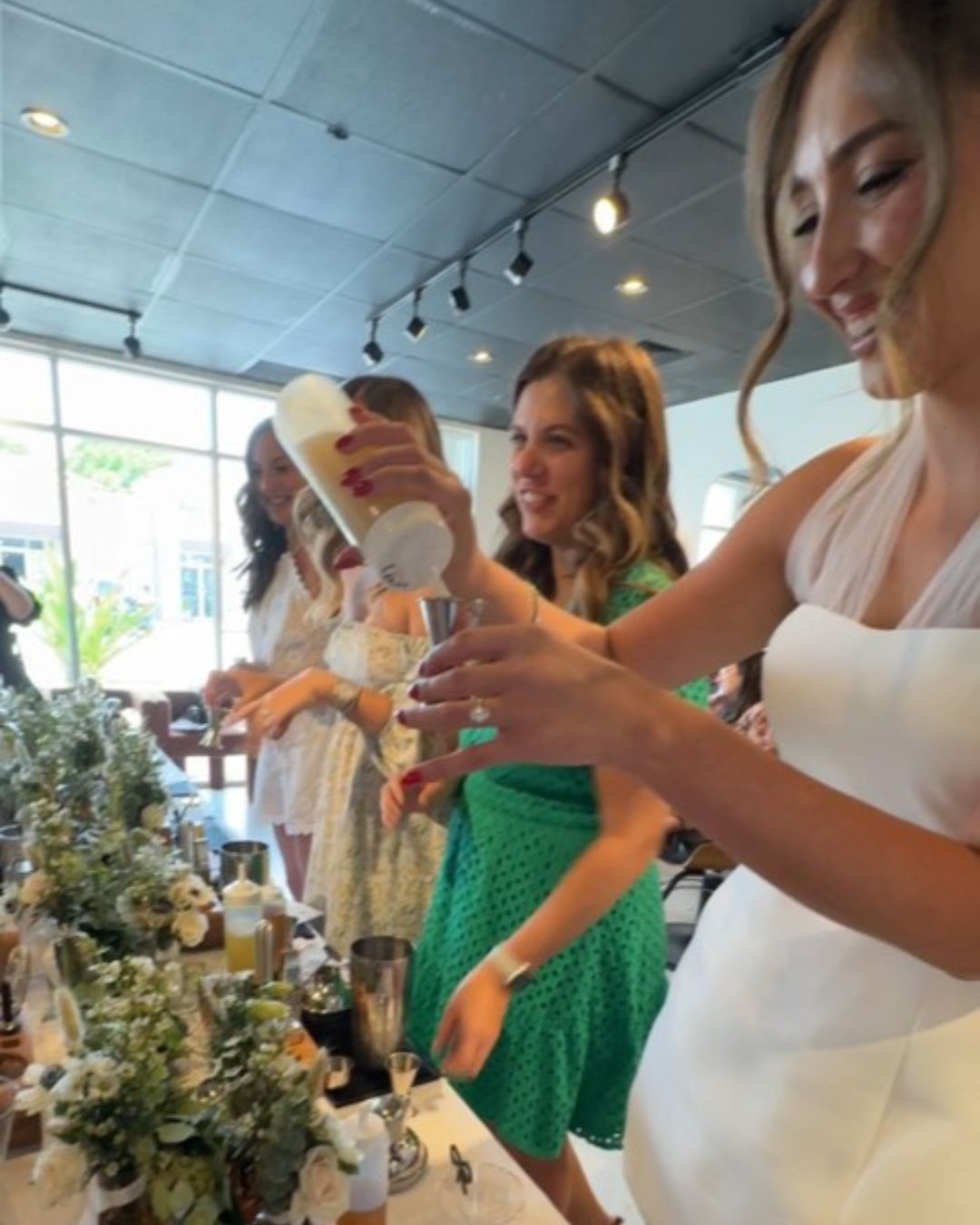 Pink cocktail in a martini glass on a bar.