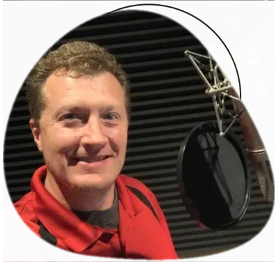 Kyle Goodnight in his recording studio sitting in front of a podcast microphone.