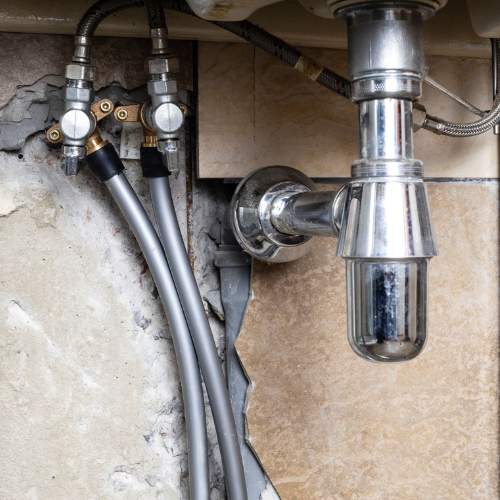 Bathroom sink drain and water lines prior to repair in a house in Spring Hill, KS