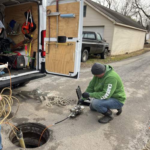 A plumber runs a camera down a residential sewer line in Spring Hill, KS