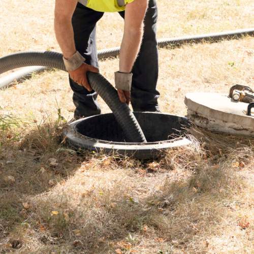 a plumber feeding a drain pipe into a septic tank that needs to be replaced in spring hill, ks