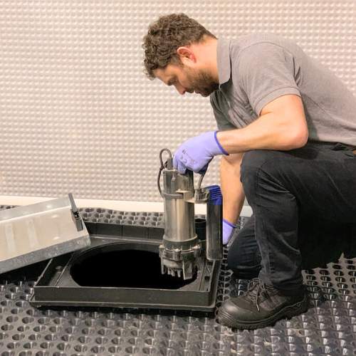 Beemer Plumbing, LLC installing a new sump pump in a finished basement in Spring Hill, KS